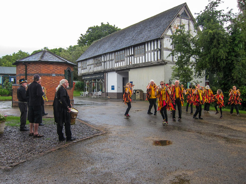 black adder morris dancing in front of the 'string of horses' building at Avoncroft
