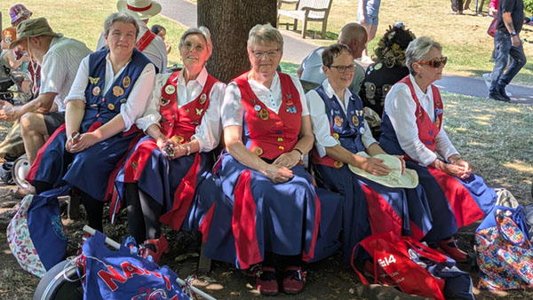 Dancers taking a break on a seat around one of the trees in Queen Elizabeth II Jubilee Gardens Bewdley