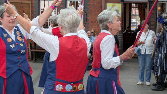Close view of 4 dancers carrying hoops
