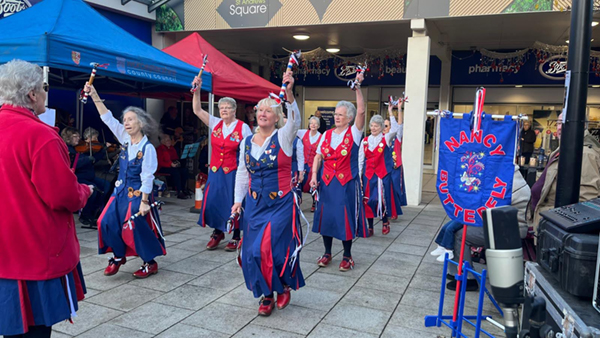 Nancy Butterfly dancing in a set of 8, raising their decorated sticks 